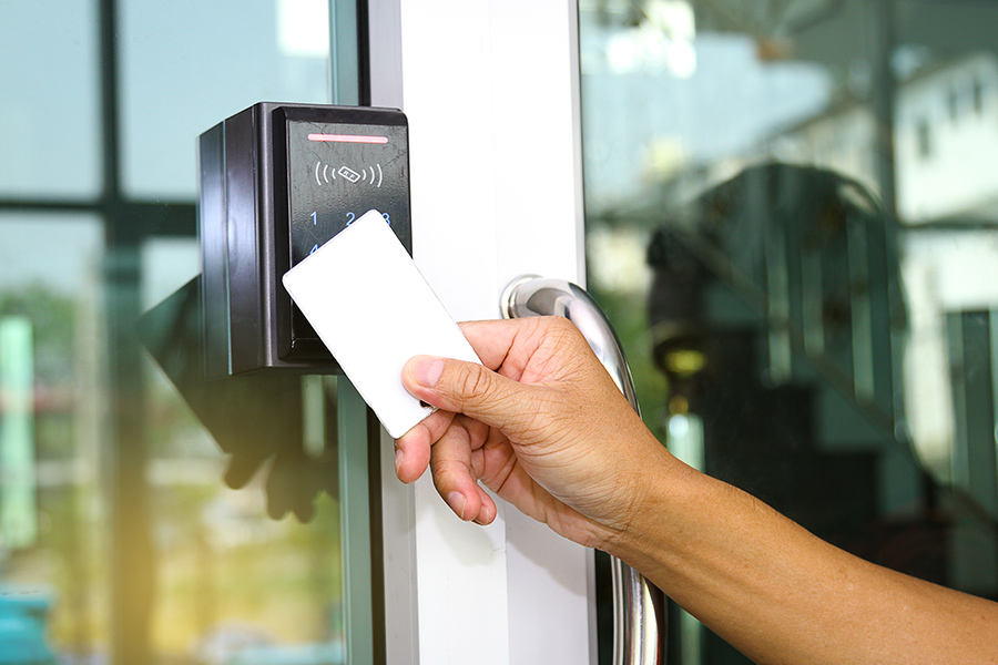 hand close up putting card in front of access control at building door austin tx